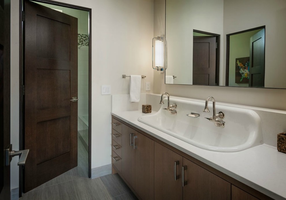 This is an example of a medium sized traditional bathroom in Seattle with flat-panel cabinets, dark wood cabinets, beige walls, ceramic flooring, a trough sink and solid surface worktops.