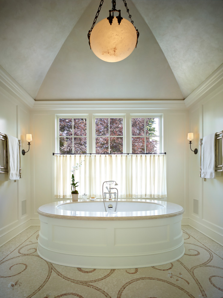 Inredning av ett klassiskt badrum, med ett undermonterat badkar, beige kakel och mosaik