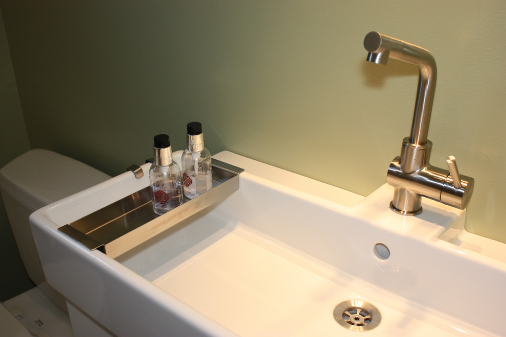 Esempio di una piccola stanza da bagno con doccia moderna con lavabo integrato, ante lisce, ante bianche, doccia ad angolo, WC a due pezzi, piastrelle in ceramica, pareti verdi e pavimento in travertino