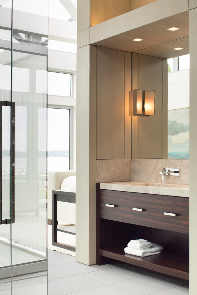 Imagen de cuarto de baño costero con armarios con paneles lisos, puertas de armario de madera en tonos medios, baldosas y/o azulejos beige y paredes beige