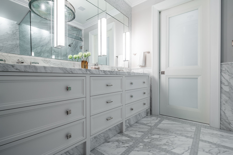 This is an example of a medium sized contemporary bathroom in New York with recessed-panel cabinets, white cabinets, a built-in bath, a corner shower, grey tiles, marble tiles, grey walls, marble flooring, a submerged sink, quartz worktops, grey floors and a hinged door.