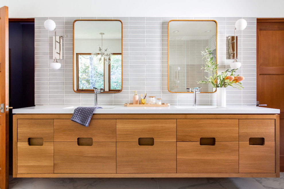 Immagine di una stanza da bagno minimal con ante lisce, ante in legno scuro, piastrelle grigie, pareti bianche, lavabo sottopiano, pavimento grigio e top bianco