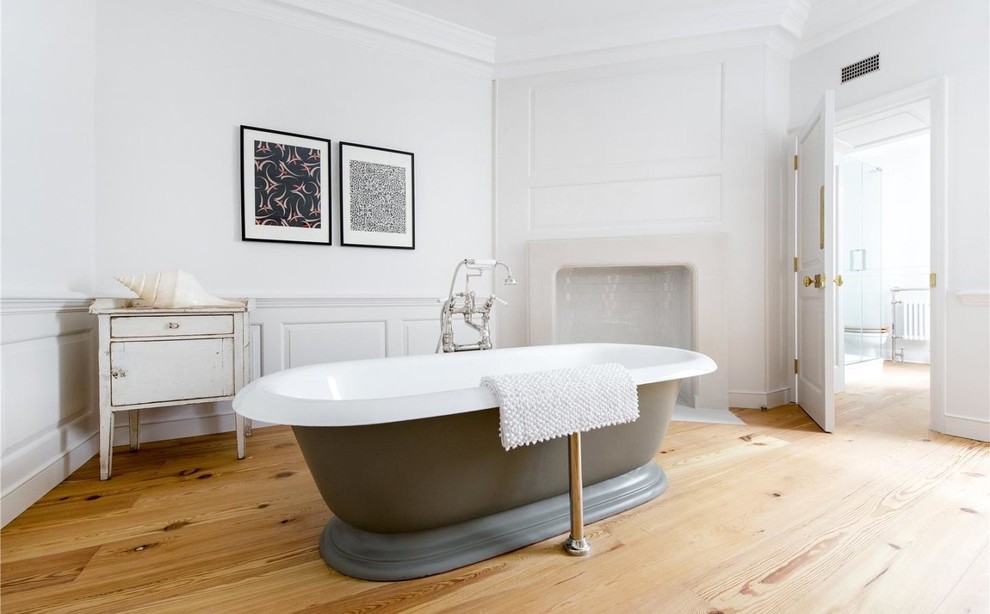 Idee per una stanza da bagno chic di medie dimensioni con vasca freestanding, pareti bianche, pavimento in legno massello medio e pavimento beige