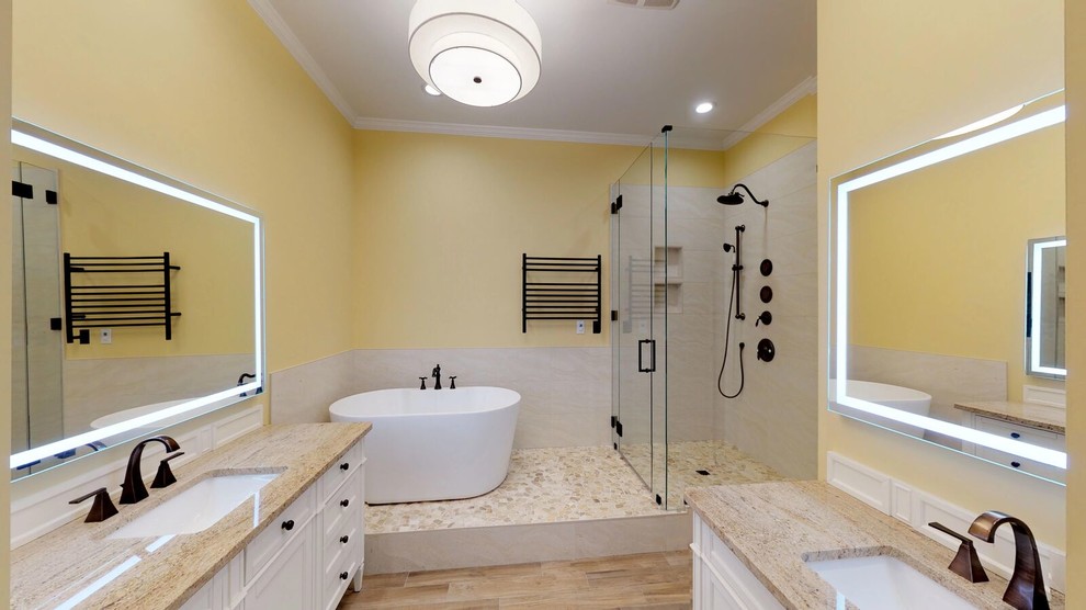 Idéer för ett mellanstort klassiskt en-suite badrum, med möbel-liknande, vita skåp, ett fristående badkar, en kantlös dusch, en toalettstol med separat cisternkåpa, beige kakel, porslinskakel, gula väggar, klinkergolv i porslin, ett undermonterad handfat, granitbänkskiva, brunt golv och dusch med gångjärnsdörr