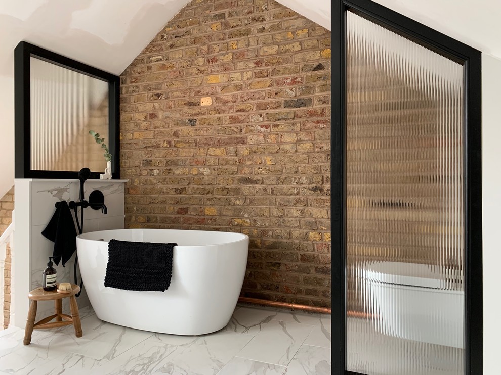 Kleines Industrial Badezimmer En Suite mit freistehender Badewanne, Toilette mit Aufsatzspülkasten, brauner Wandfarbe, weißem Boden, weißen Fliesen, Porzellanfliesen, Porzellan-Bodenfliesen, gewölbter Decke und Ziegelwänden in London