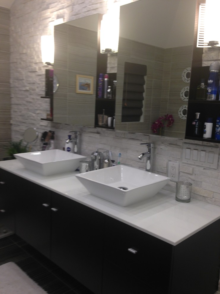 Example of a mid-sized trendy master stone tile bathroom design in Other with flat-panel cabinets, black cabinets, a vessel sink and quartzite countertops