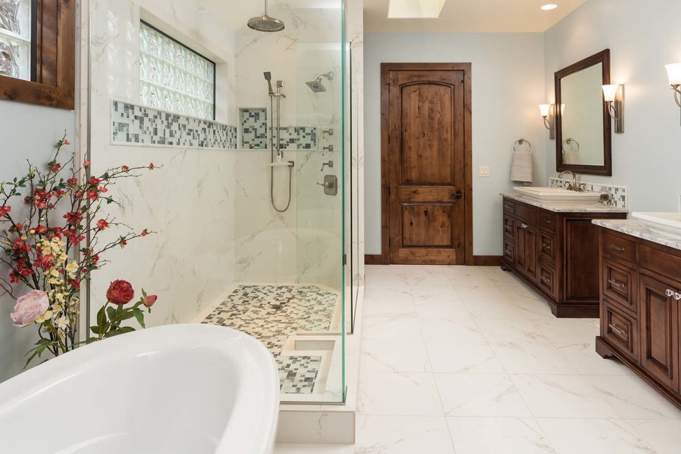 Example of a large mountain style master gray tile and glass tile marble floor bathroom design in Other with beaded inset cabinets, dark wood cabinets, blue walls, a vessel sink and marble countertops