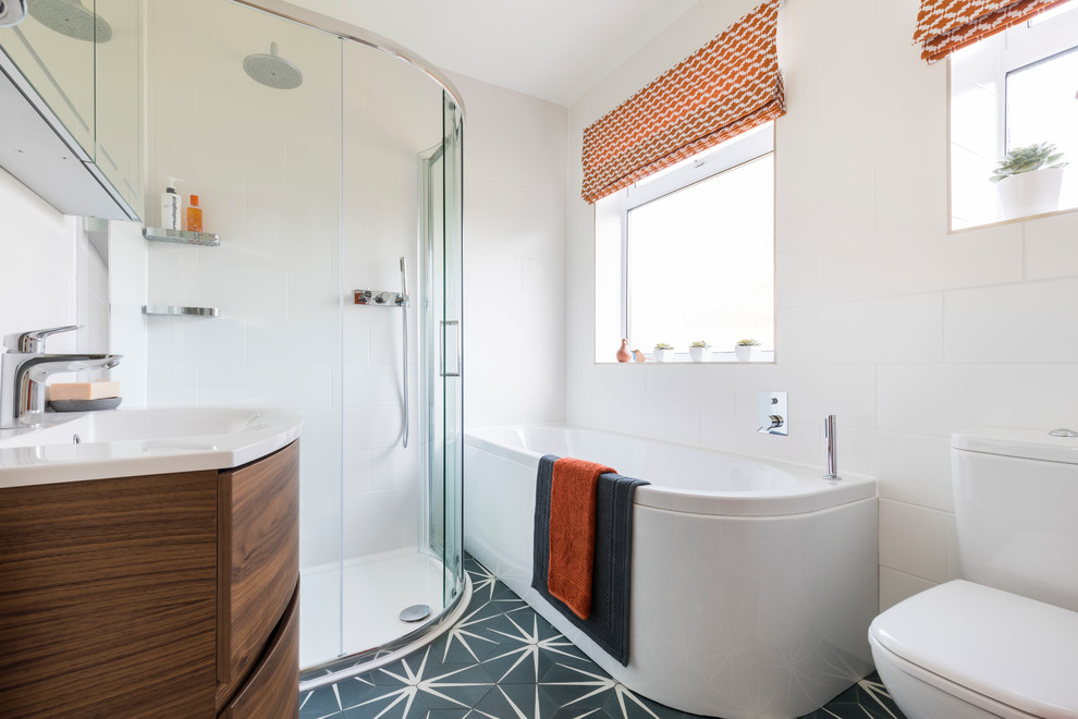 Inspiration for a medium sized contemporary bathroom in London with a built-in bath, a walk-in shower, a two-piece toilet, white tiles, ceramic tiles, white walls, cement flooring, blue floors, a sliding door, flat-panel cabinets, dark wood cabinets and a console sink.