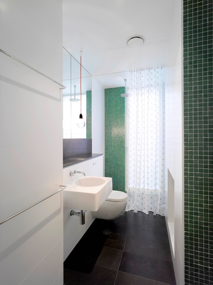 Inspiration för mellanstora moderna en-suite badrum, med en öppen dusch, en vägghängd toalettstol, grön kakel, mosaik, vita väggar, skiffergolv, ett väggmonterat handfat, ett platsbyggt badkar, kaklad bänkskiva, svart golv och med dusch som är öppen