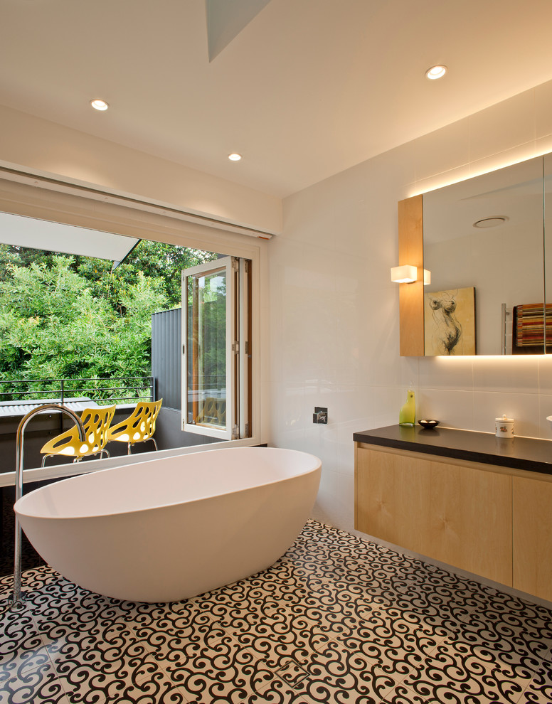 シドニーにあるコンテンポラリースタイルのおしゃれなマスターバスルーム (フラットパネル扉のキャビネット、淡色木目調キャビネット、置き型浴槽、白い壁) の写真