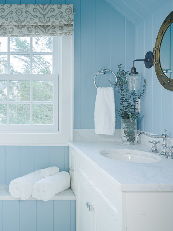 Mittelgroßes Maritimes Badezimmer mit Schrankfronten mit vertiefter Füllung, weißen Schränken, blauer Wandfarbe und Einbauwaschbecken in New York