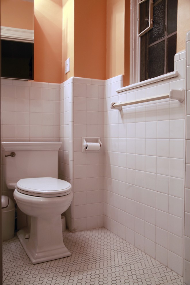Modelo de cuarto de baño bohemio con sanitario de una pieza, baldosas y/o azulejos blancos, baldosas y/o azulejos de cerámica, suelo de baldosas de cerámica, aseo y ducha y parades naranjas