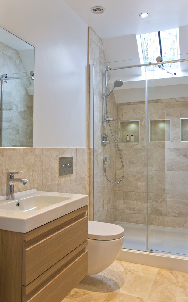 Classic shower room bathroom in Gloucestershire with a console sink, flat-panel cabinets, light wood cabinets, a wall mounted toilet, beige tiles, white walls and an alcove shower.