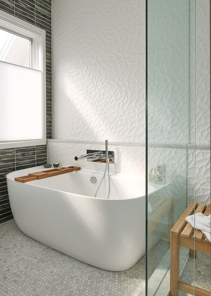 Modelo de cuarto de baño contemporáneo con bañera exenta, baldosas y/o azulejos blancos, suelo con mosaicos de baldosas y suelo gris