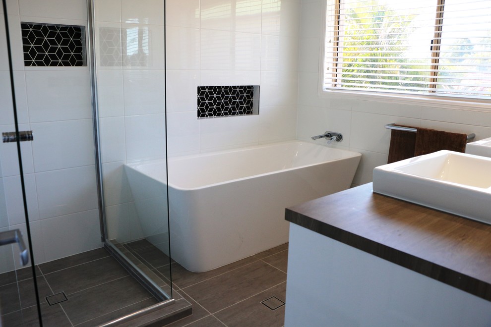 Immagine di una stanza da bagno per bambini minimal di medie dimensioni con doccia ad angolo, piastrelle bianche, top in laminato e porta doccia a battente