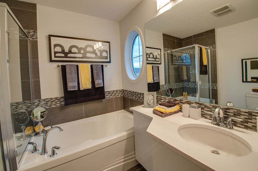 Modernes Badezimmer mit Unterbauwaschbecken, flächenbündigen Schrankfronten, beigen Schränken, Badewanne in Nische, braunen Fliesen und Stäbchenfliesen in Calgary