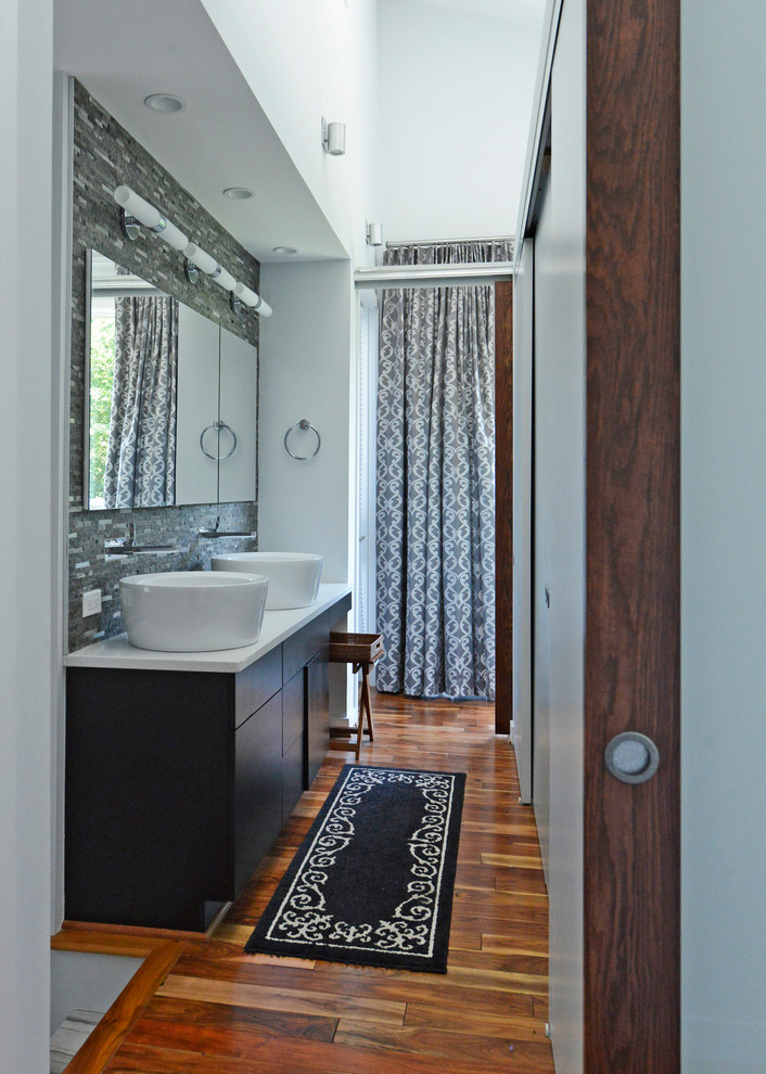 Medium sized contemporary ensuite bathroom in DC Metro with flat-panel cabinets, dark wood cabinets, a freestanding bath, a walk-in shower, dark hardwood flooring, a vessel sink, laminate worktops, matchstick tiles, white walls, brown floors and a shower curtain.