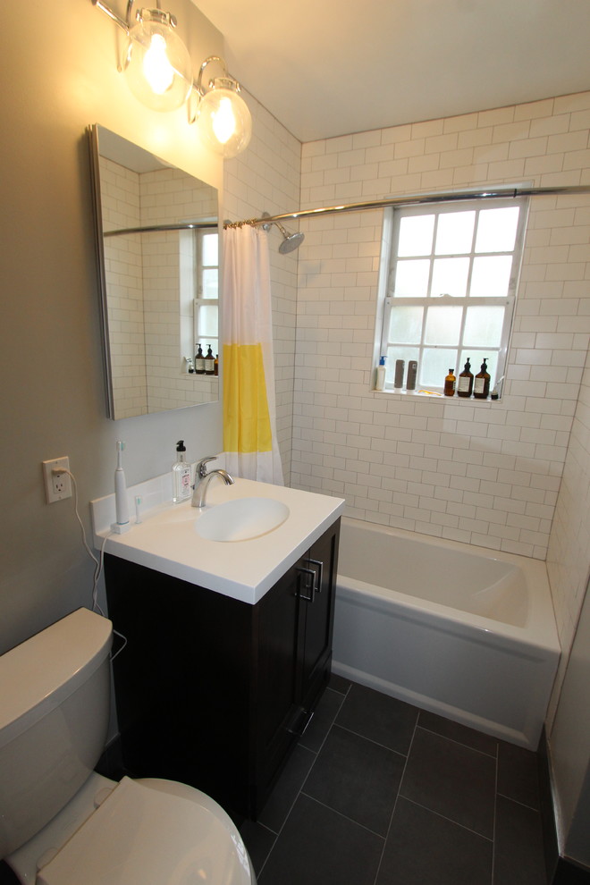 Foto på ett mellanstort funkis badrum, med möbel-liknande, skåp i mörkt trä, ett badkar i en alkov, en dusch/badkar-kombination, en toalettstol med separat cisternkåpa, vit kakel, keramikplattor, grå väggar, klinkergolv i keramik, ett integrerad handfat, bänkskiva i akrylsten, grått golv och dusch med duschdraperi