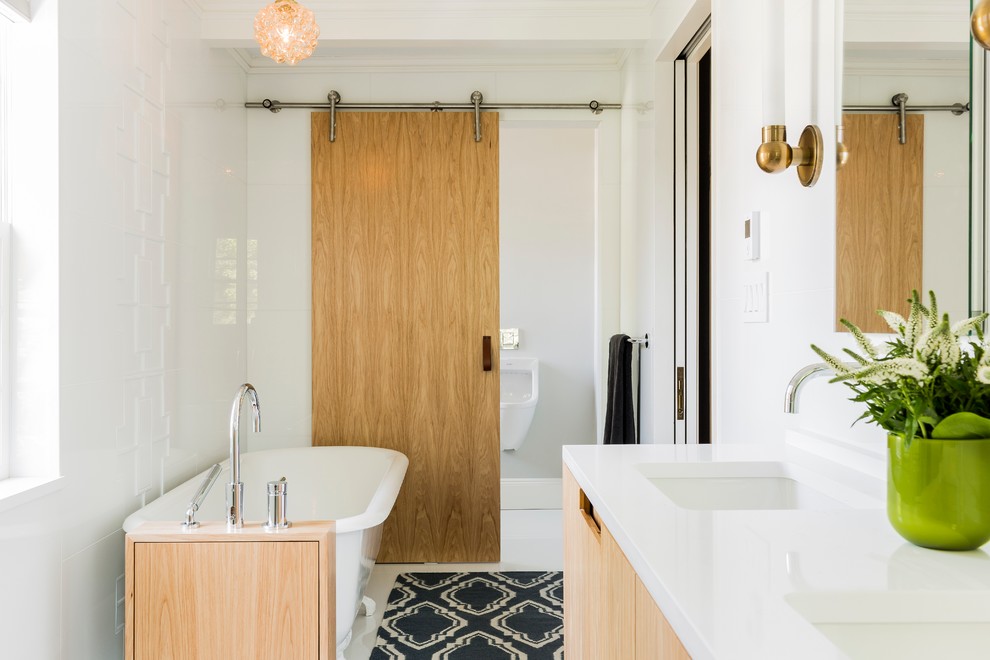 ボストンにあるトランジショナルスタイルのおしゃれな浴室 (フラットパネル扉のキャビネット、淡色木目調キャビネット、猫足バスタブ、小便器、白い壁、アンダーカウンター洗面器) の写真