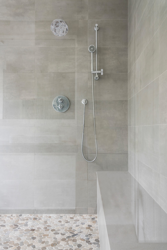 Cette image montre une salle de bain principale traditionnelle de taille moyenne avec une baignoire indépendante, un mur gris, un sol en carrelage de porcelaine, un sol gris et une cabine de douche à porte battante.