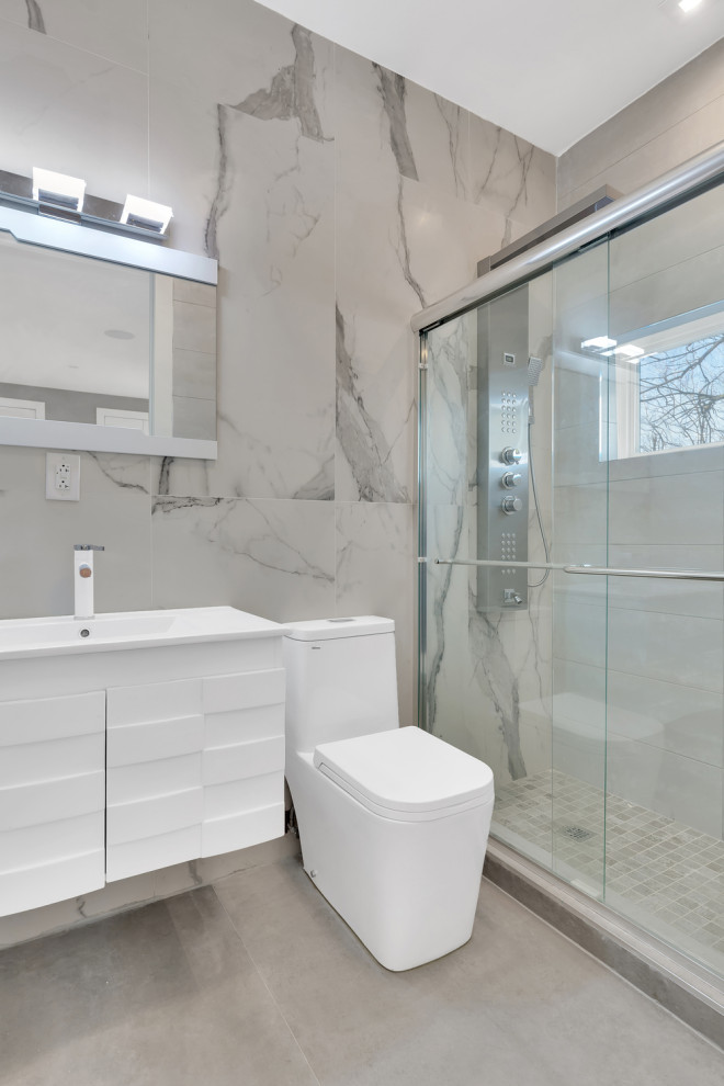 Medium sized modern bathroom in New York with louvered cabinets, white cabinets, a one-piece toilet, grey tiles, ceramic tiles, ceramic flooring, a built-in sink, solid surface worktops, grey floors, a sliding door and white worktops.