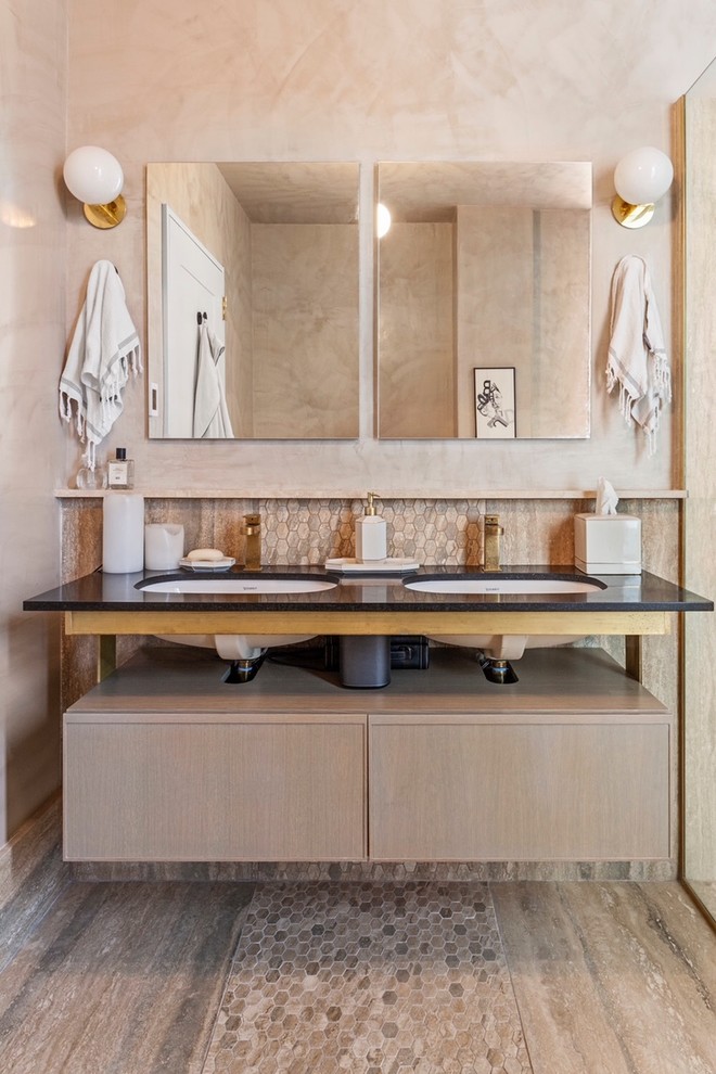 Ispirazione per una stanza da bagno contemporanea con ante lisce, ante in legno chiaro, piastrelle beige, piastrelle a mosaico, pareti beige, lavabo sottopiano, pavimento beige e top nero