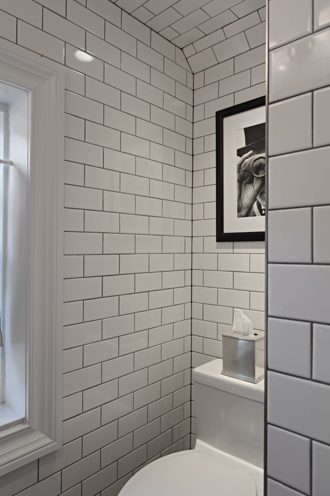 Bild på ett litet funkis badrum med dusch, med en hörndusch, en toalettstol med hel cisternkåpa, vit kakel, porslinskakel, vita väggar, klinkergolv i keramik, ett piedestal handfat och grått golv