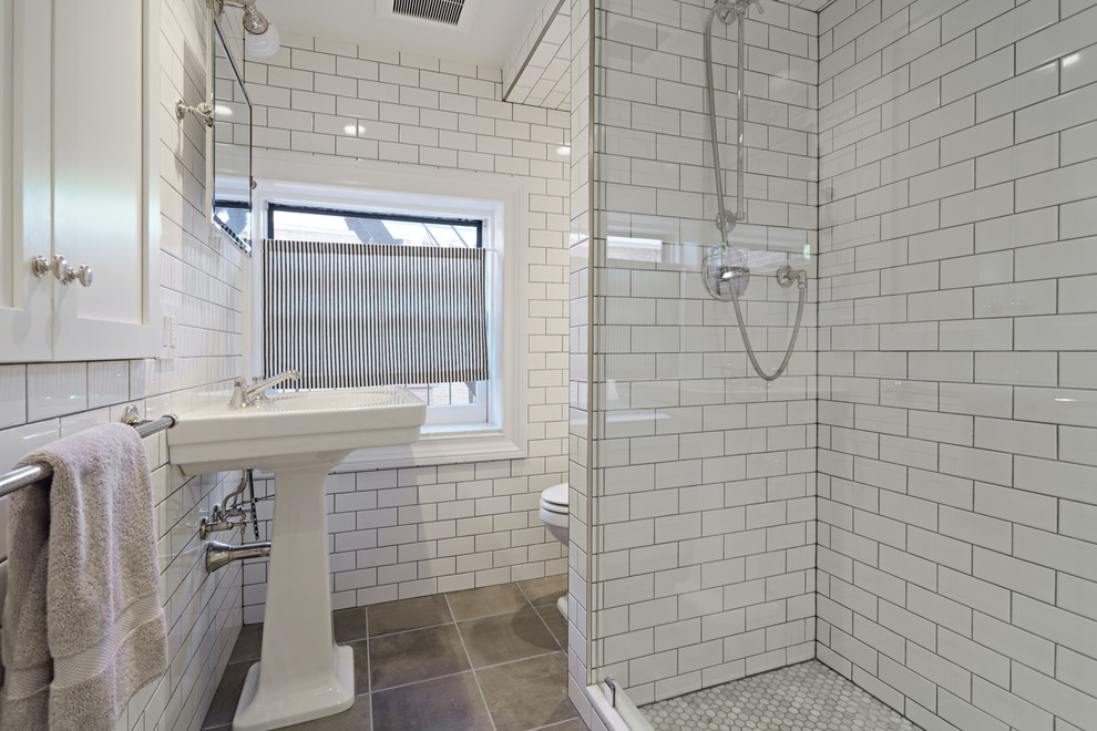Esempio di una piccola stanza da bagno con doccia moderna con doccia ad angolo, WC monopezzo, piastrelle bianche, piastrelle in gres porcellanato, pareti bianche, pavimento con piastrelle in ceramica, lavabo a colonna e pavimento grigio