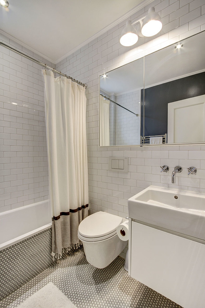 Inspiration för ett litet funkis badrum, med ett undermonterad handfat, släta luckor, vita skåp, en vägghängd toalettstol, vit kakel, tunnelbanekakel, vita väggar och klinkergolv i keramik