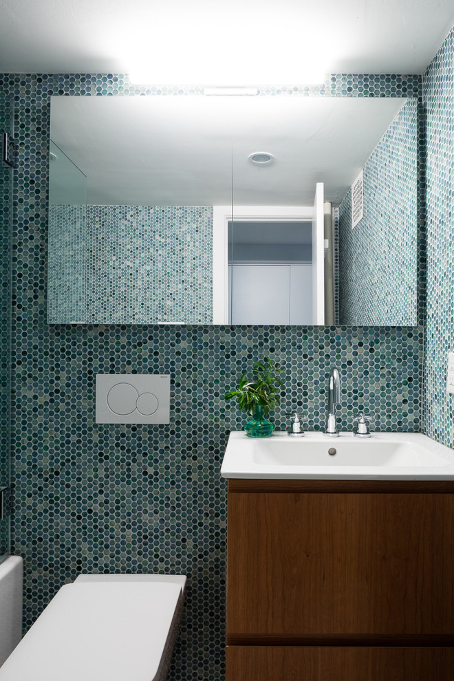 Idées déco pour une salle de bain contemporaine en bois brun avec un placard à porte plane, une douche à l'italienne, un carrelage bleu, mosaïque, un sol en galet, un sol noir et une cabine de douche à porte battante.