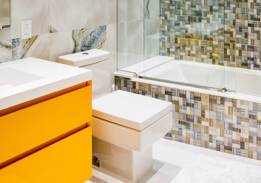 Immagine di una stanza da bagno minimal di medie dimensioni con ante gialle, vasca da incasso, ante lisce, vasca/doccia, WC monopezzo, porta doccia scorrevole e lavabo integrato
