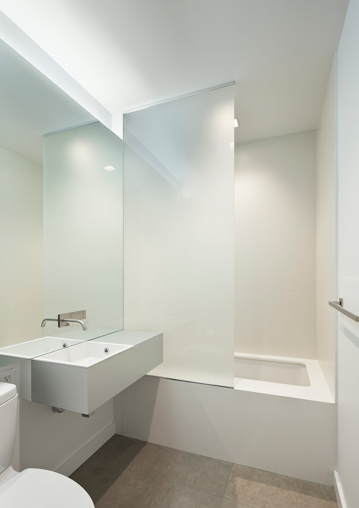 Пример оригинального дизайна: ванная комната в стиле модернизм с белой плиткой, белыми стенами и душем над ванной