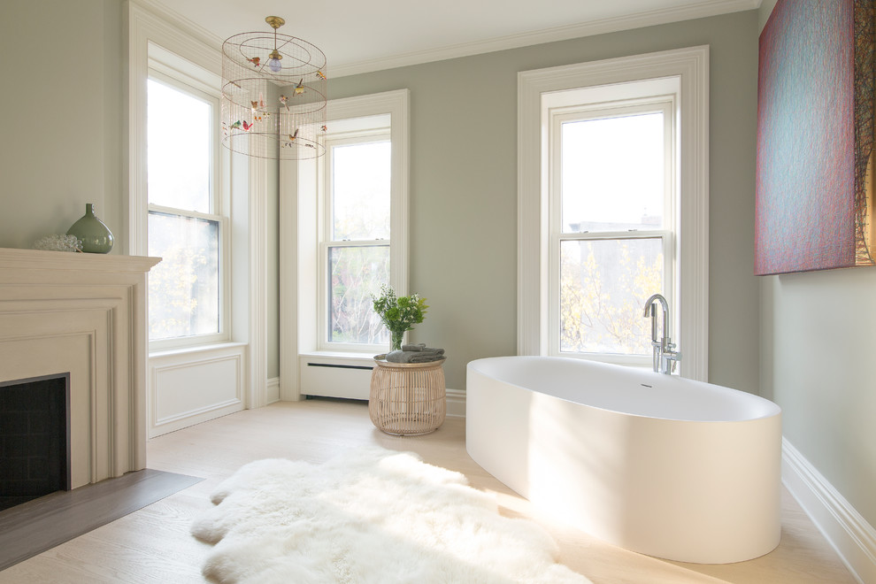 Ejemplo de cuarto de baño principal tradicional grande con bañera exenta, paredes verdes y suelo de madera clara