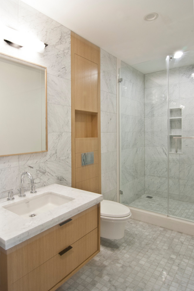 Idées déco pour une grande salle de bain contemporaine en bois clair avec un placard à porte plane, un carrelage gris, du carrelage en marbre, un mur gris, un sol en marbre, un plan de toilette en marbre, un sol gris, une cabine de douche à porte battante et un plan de toilette gris.
