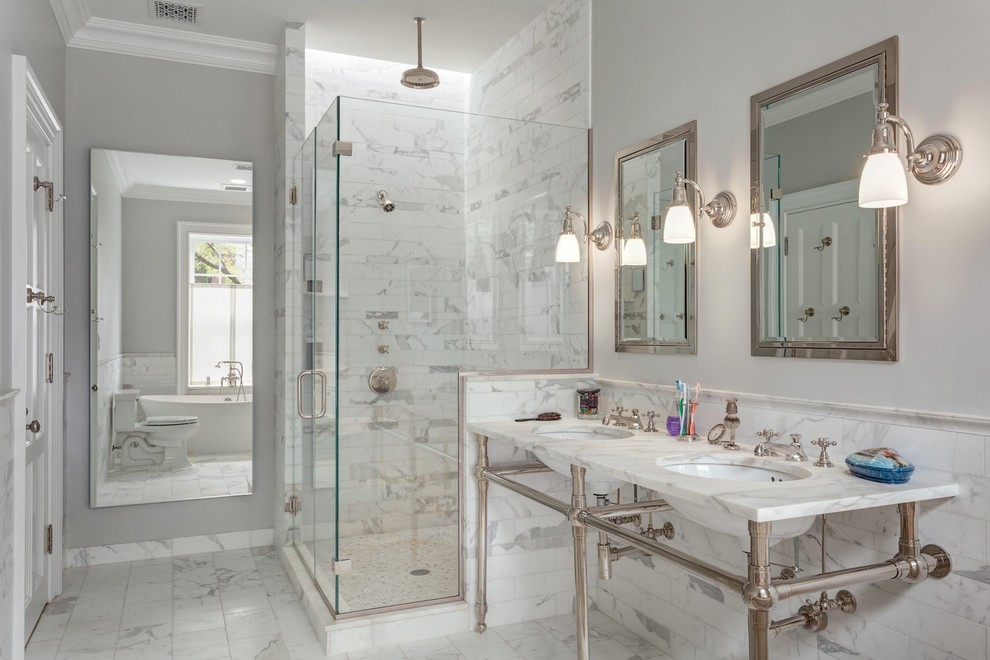 Classic bathroom in New York with a corner shower, grey tiles, multi-coloured tiles, white tiles, grey walls, a console sink and a hinged door.