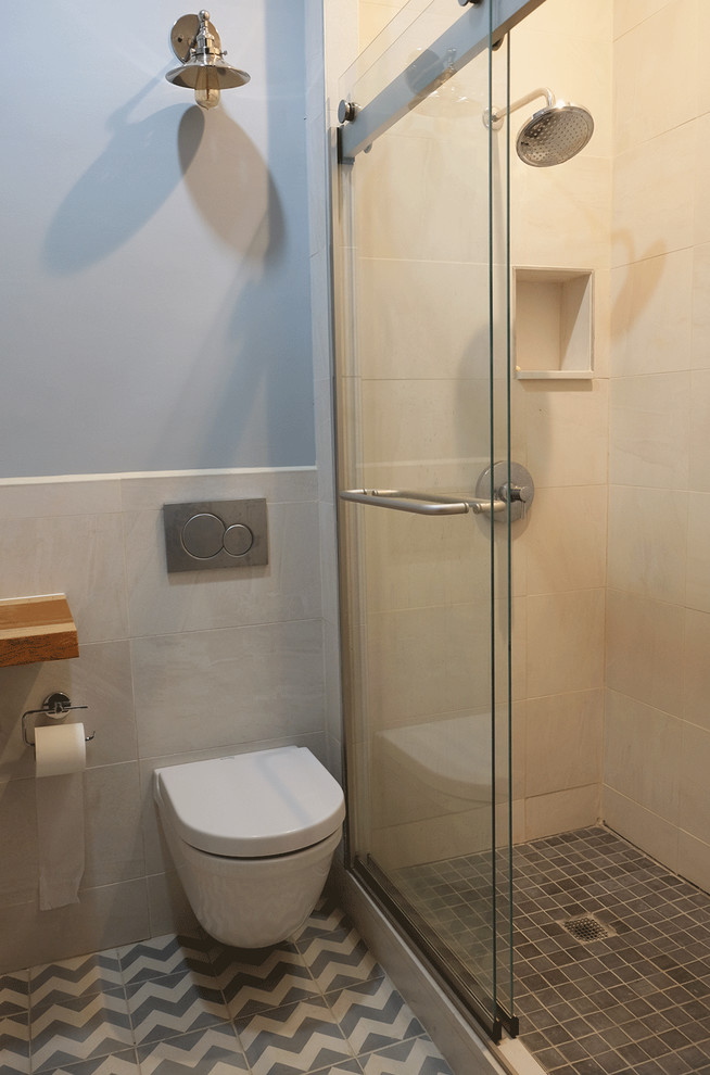 Modern inredning av ett litet badrum med dusch, med bruna skåp, en dusch i en alkov, en vägghängd toalettstol, beige kakel, porslinskakel, blå väggar, cementgolv, ett nedsänkt handfat, träbänkskiva, grått golv och dusch med skjutdörr