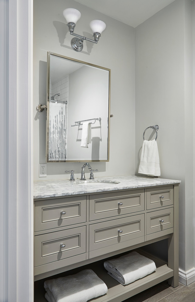 Example of a mid-sized transitional 3/4 white tile and subway tile medium tone wood floor and brown floor bathroom design in New York with furniture-like cabinets, beige cabinets, gray walls, an undermount sink and marble countertops