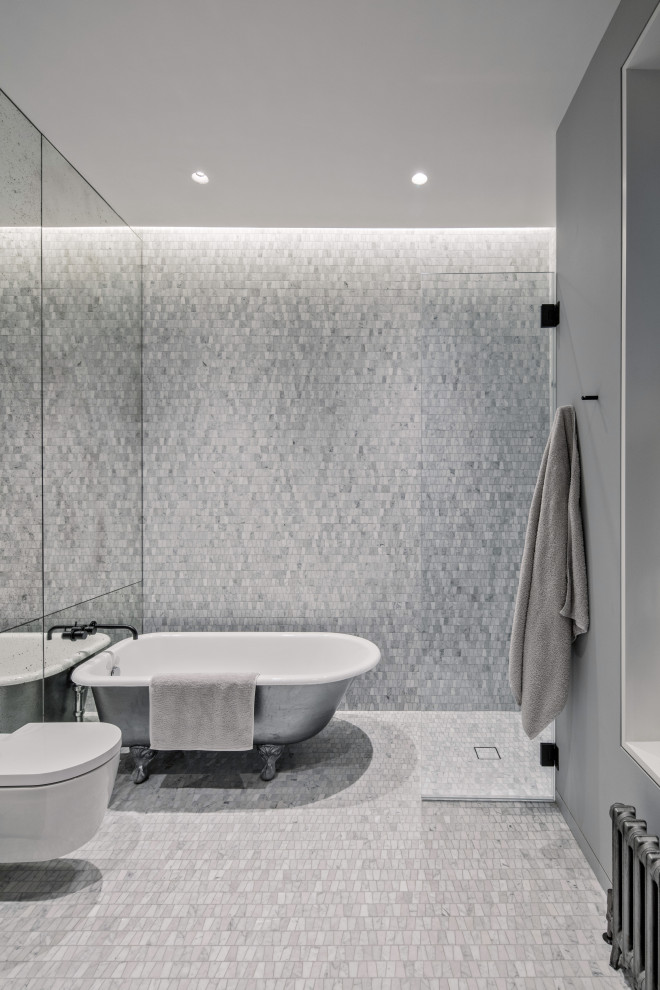 Inspiration for a large modern gray tile and stone tile marble floor and gray floor bathroom remodel in New York with flat-panel cabinets, white cabinets, a wall-mount toilet, gray walls, a wall-mount sink, marble countertops, a hinged shower door and white countertops