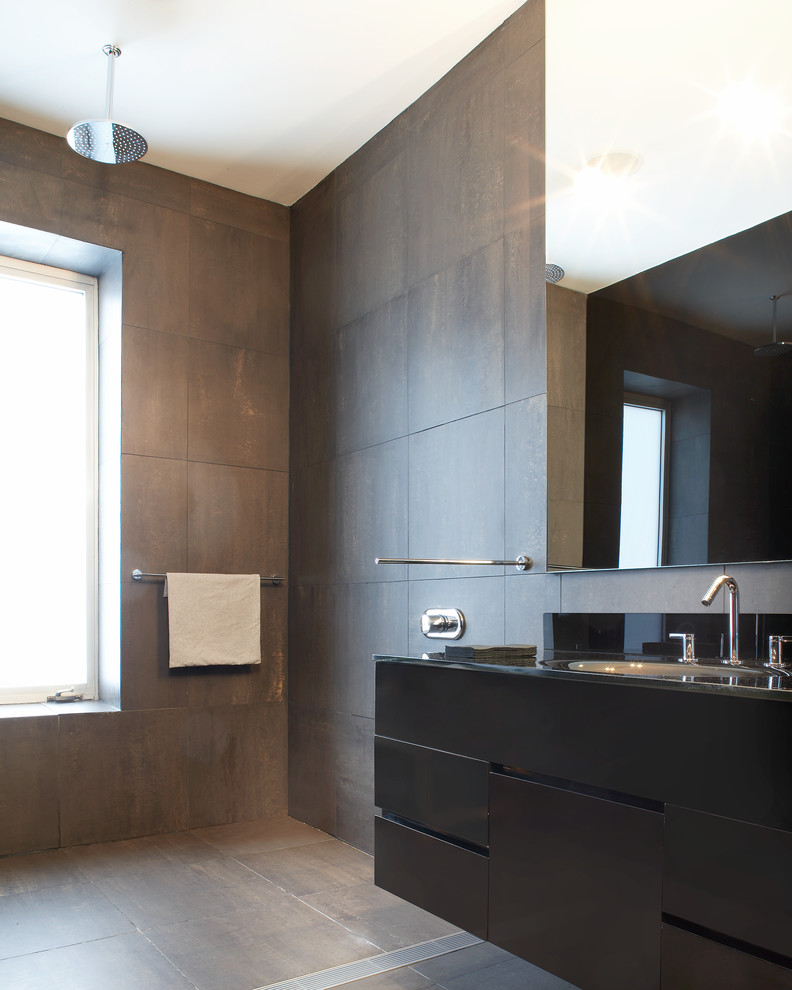 Inspiration for a medium sized modern family bathroom in New York with flat-panel cabinets, black cabinets, a walk-in shower, black tiles, porcelain tiles, black walls, porcelain flooring, an integrated sink, glass worktops, black floors and an open shower.