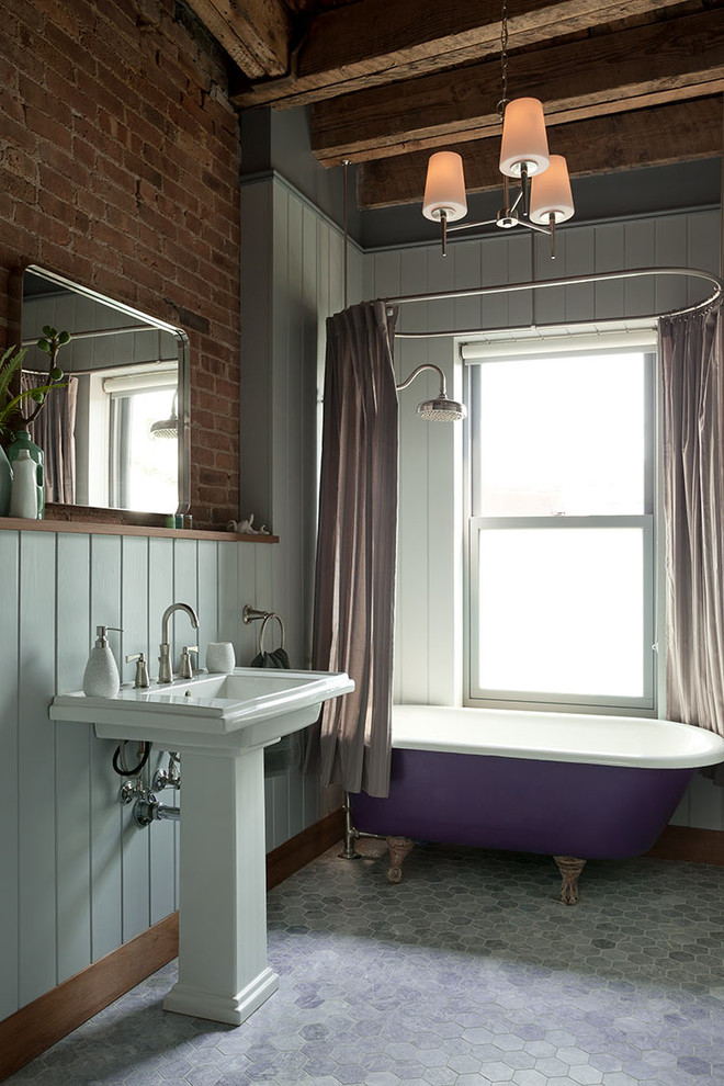 Imagen de cuarto de baño rural con bañera con patas, combinación de ducha y bañera, paredes azules, lavabo con pedestal, suelo gris y ducha con cortina