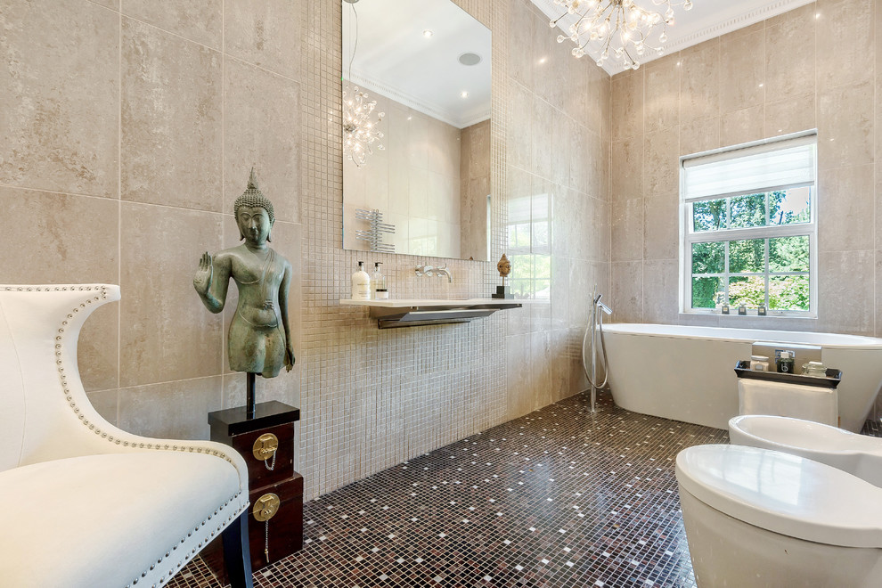 Immagine di una stanza da bagno padronale boho chic con vasca freestanding, WC monopezzo, piastrelle beige, pareti beige, pavimento con piastrelle a mosaico, lavabo sospeso e pavimento marrone