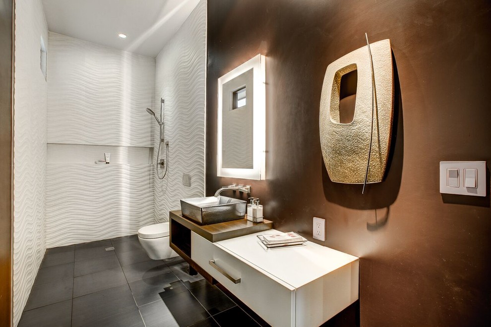 На фото: ванная комната в современном стиле с плоскими фасадами, белыми фасадами, открытым душем, инсталляцией, белой плиткой, коричневыми стенами, душевой кабиной, настольной раковиной, черным полом, открытым душем и белой столешницей