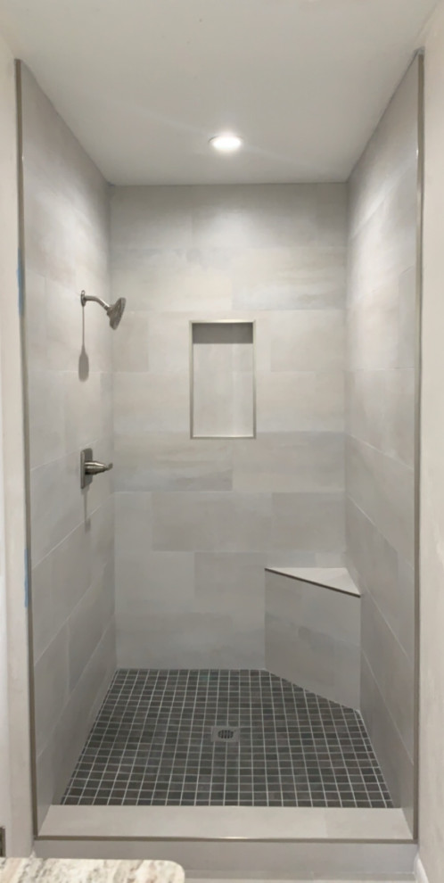 На фото: главная ванная комната среднего размера в стиле модернизм с фасадами в стиле шейкер, серыми фасадами, ванной в нише, душем над ванной, раздельным унитазом, серой плиткой, керамогранитной плиткой, серыми стенами, полом из керамогранита, врезной раковиной, столешницей из кварцита, серым полом, душем с распашными дверями, серой столешницей, сиденьем для душа, тумбой под две раковины и встроенной тумбой с