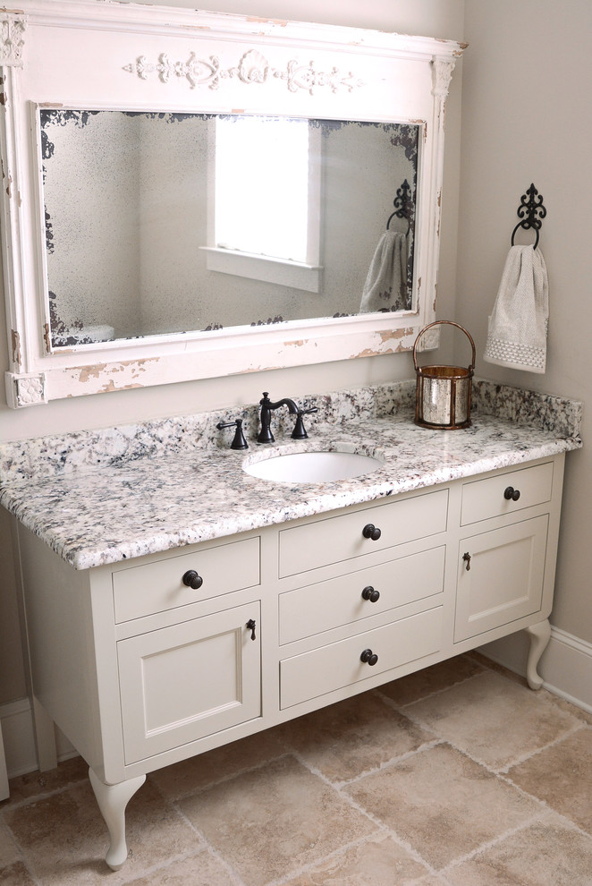 This is an example of a traditional bathroom in New Orleans with freestanding cabinets, white cabinets and a submerged sink.