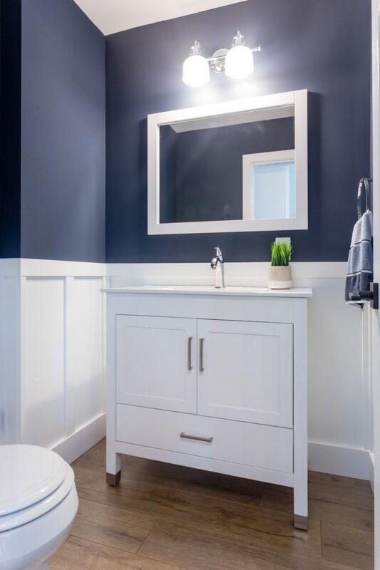 Immagine di una piccola stanza da bagno con doccia stile americano con ante in stile shaker, ante bianche, WC monopezzo, pareti blu, pavimento in laminato, lavabo sottopiano, top in quarzo composito, pavimento marrone e top bianco