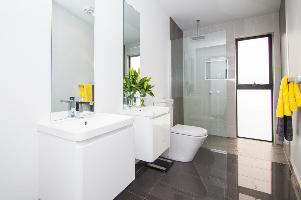 Kleines Modernes Badezimmer En Suite mit flächenbündigen Schrankfronten, weißen Schränken, offener Dusche, Toilette mit Aufsatzspülkasten, grauen Fliesen, Keramikfliesen, weißer Wandfarbe, Keramikboden, integriertem Waschbecken und Laminat-Waschtisch in Hobart