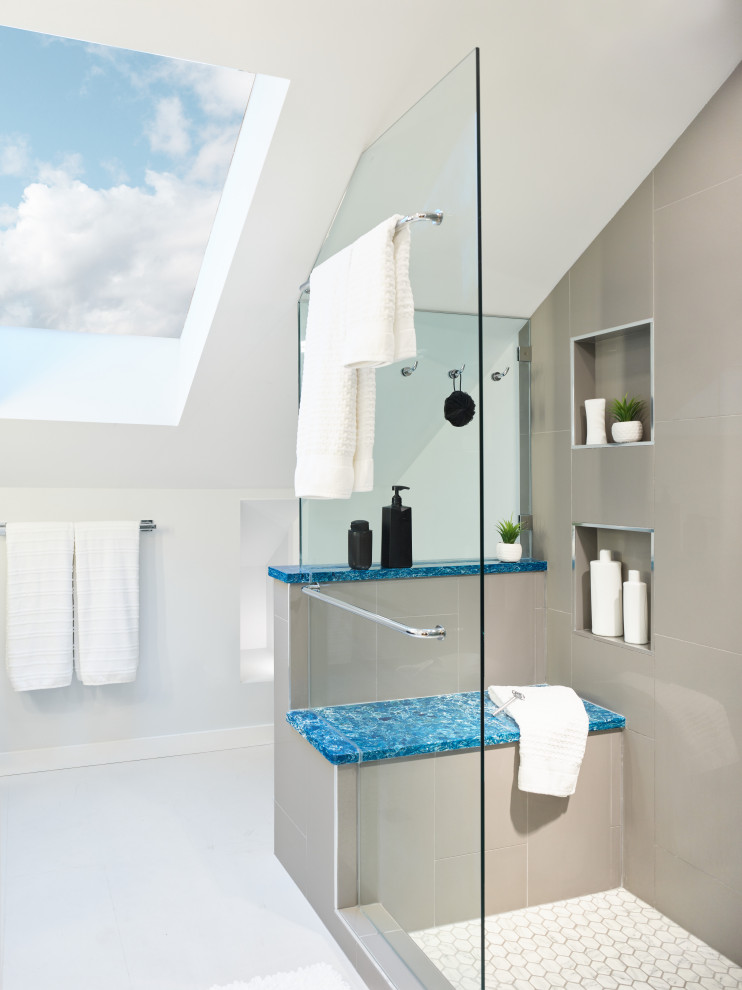 Photo of a small modern ensuite bathroom in Vancouver with freestanding cabinets, dark wood cabinets, an alcove shower, grey tiles, porcelain tiles, white walls, bamboo flooring, a submerged sink, quartz worktops, beige floors, a hinged door, blue worktops, a shower bench, a single sink, a built in vanity unit and a vaulted ceiling.
