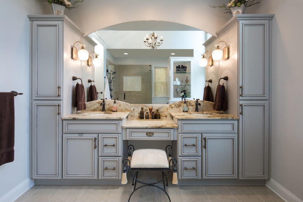 Klassisk inredning av ett mellanstort en-suite badrum, med luckor med upphöjd panel, ett badkar med tassar, en hörndusch, beige kakel, stenkakel, grå väggar, klinkergolv i porslin, ett undermonterad handfat och granitbänkskiva