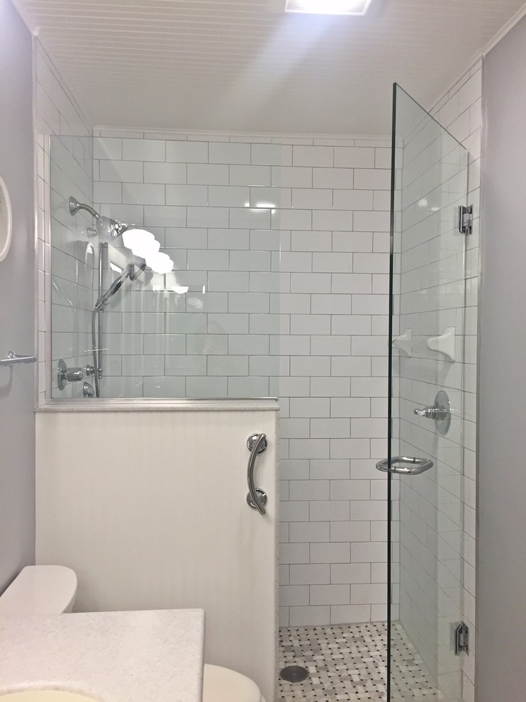 Ejemplo de cuarto de baño infantil moderno pequeño con armarios con paneles empotrados, puertas de armario blancas, baldosas y/o azulejos blancos y paredes grises