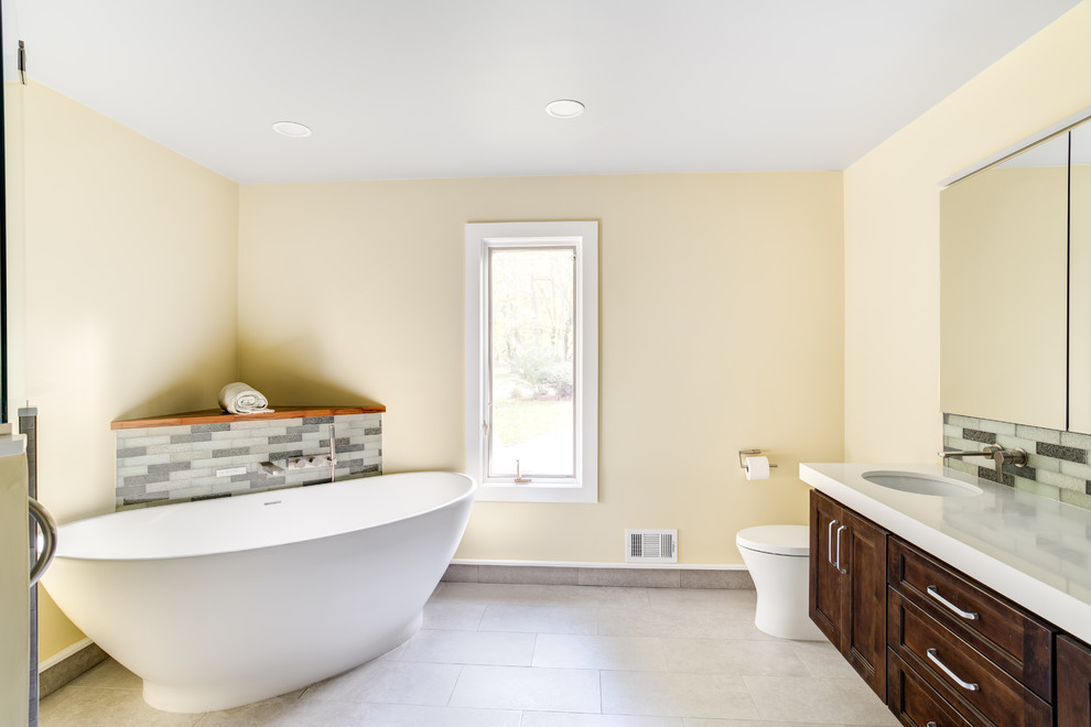 Aménagement d'une grande salle de bain principale contemporaine en bois brun avec un placard avec porte à panneau encastré, une baignoire indépendante, une douche d'angle, WC à poser, un carrelage multicolore, des carreaux de porcelaine, un mur jaune, un sol en carrelage de porcelaine, un lavabo encastré, un plan de toilette en quartz, un sol gris et une cabine de douche à porte battante.